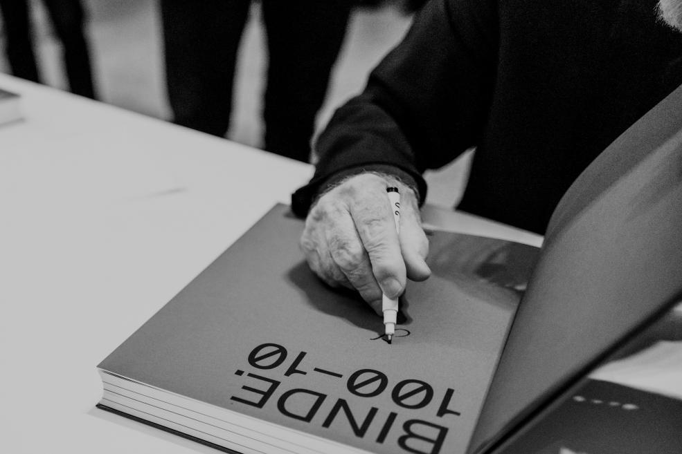 Photographer Gunars Binde signs the book.