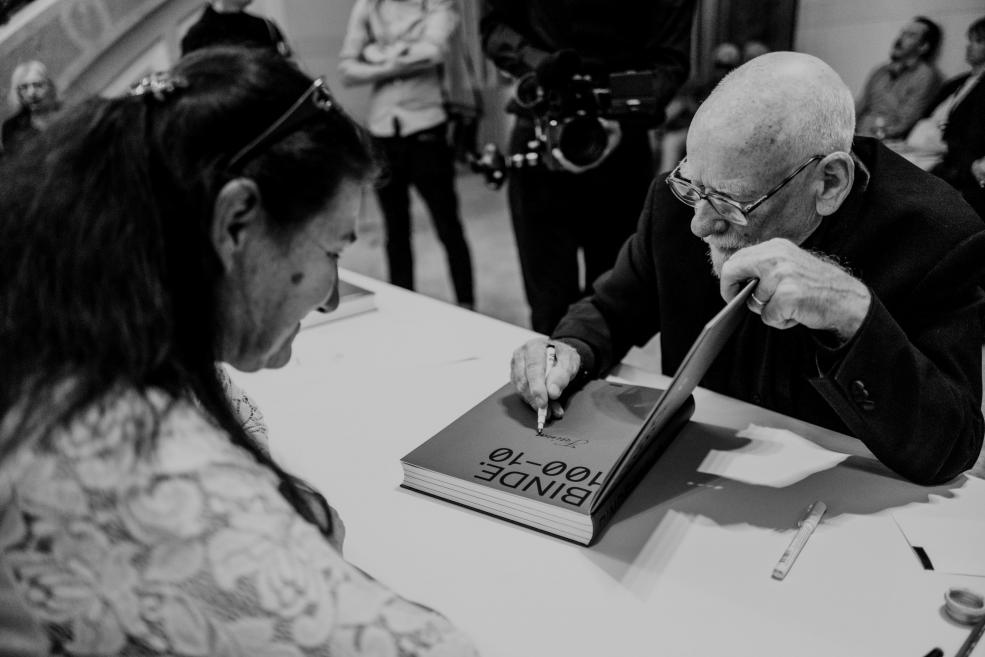 Photographer Gunars Binde signs the book.